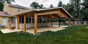 Spacious covered wooden patio built onto a two-story home, demonstrating how property size enables custom exterior building additions.